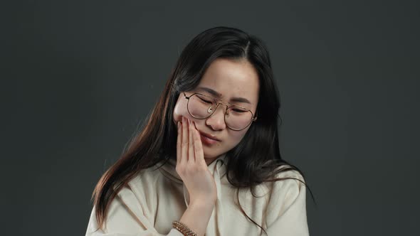 Asian Woman with Tooth Pain on Grey Studio background.Toothache, Dental Problems