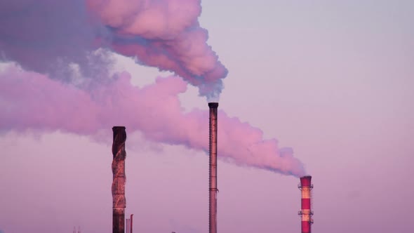 Three Chimneys Smoking Against a Purple Sky