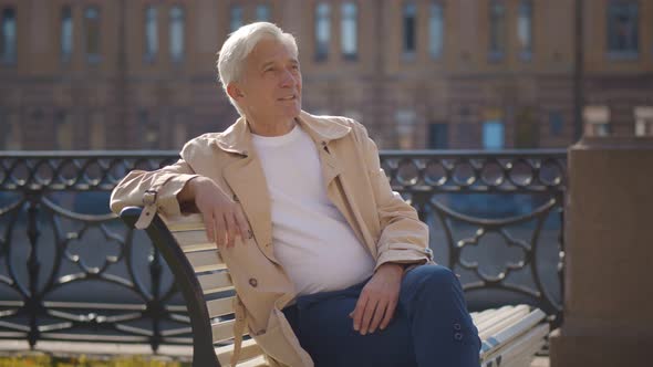 Portrait of Retired Elegant Man Relaxing on Bench in City Center