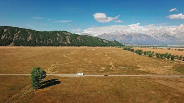 Aerial video of heavy mountains, blue skies and endless prairies near Mormon Row, Wyoming, USA