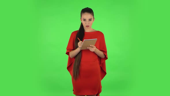 Pretty Young Woman Is Standing and Thinking, Then Dissatisfied Writing with Pencil in Notebook