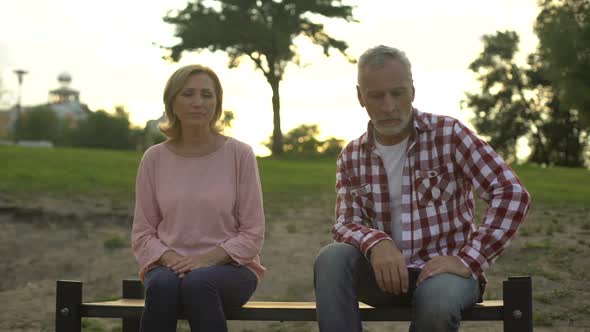 Crisis in Relationship, Retired Man and Woman Sitting on Bench in Park, Quarrel