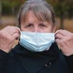 Portrait of a Senior Woman Putting on a Medical Mask and Looking Seriously at the Camera. - VideoHive Item for Sale