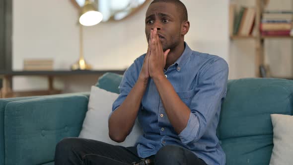 Young African Man Having Loss on Video Game on Sofa