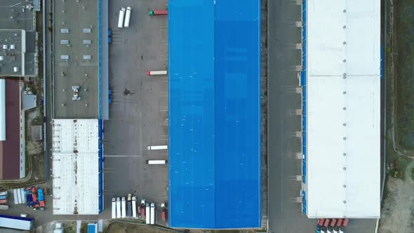 Aerial Top Down View of the Large Logistics Park with Warehouse with Some Semi-trailers Trucks.