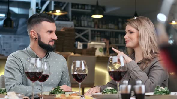 Hipster Smiling Man and Pretty Woman Talking in Dinner Date at Restaurant
