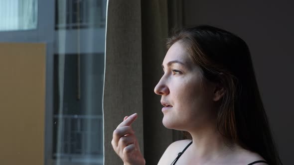 Positive Woman Takes Pill and Drinks Water in Hotel Room