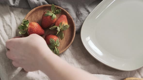 Girl or Woman Take Wooden Bowl with Strawberries with Her Hand and Ready to Decorate Croissants