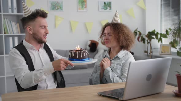 Holiday Online Smiling Girl Has Fun with Husband and Blows Out Candles on Birthday Cake During Gala