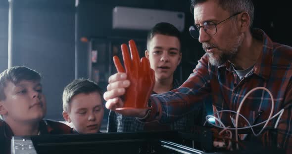 Teacher and Students Using 3D Printer