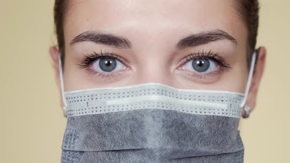 Close Up Face of Young Woman in Protective Medical Mask Looking at Camera