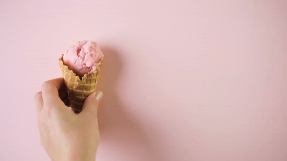 Waffle ice cream cones with plate of ice cream scoops on a pink background.