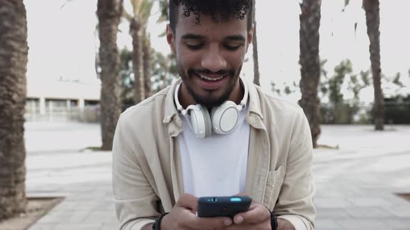 Front View of Young Man Using Cellphone Outdoors