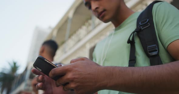 Close up of mixed race man using smartphone in the street