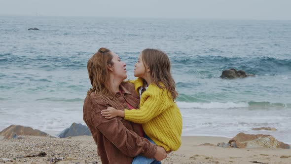 Young Mom Is Holding Her Daughter In Her Arms