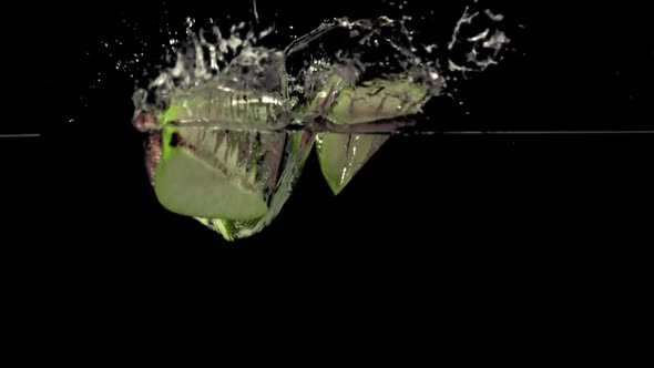 Super Slow Motion Pieces of Pear Fall Under the Water with Air Bubbles