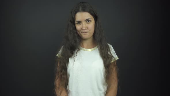 Girl Looks Straight and Smiles Standing on Studio Stage