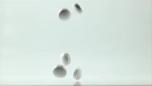 A Bunch of Pills Fall on the Table on a White Background