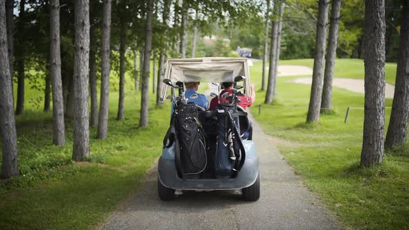 Golf cart driving through a beautiful golf course in slow motion.