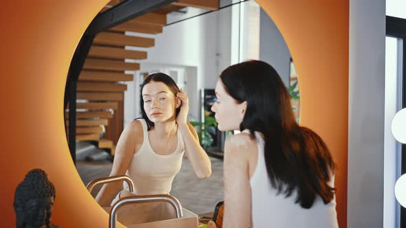 Young Cute Woman with Vitiligo Skin Looking at Mirror Enjoying Her Appearance and Freshness Tracking