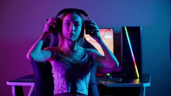 Tattooed Gamer Girl Sitting By the PC - Putting on Her Headphones and Starts Playing