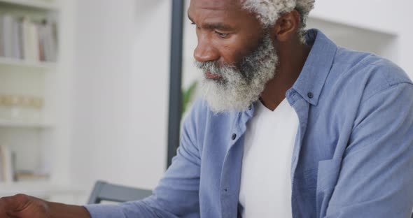 Video of sad african american senior man with eating toast