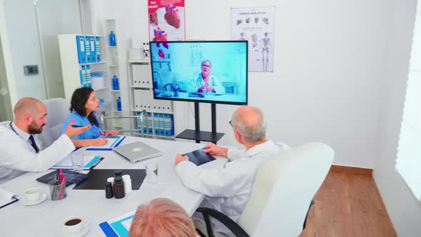 Team of Medical Staff During Video Conference with Doctor in Hospital