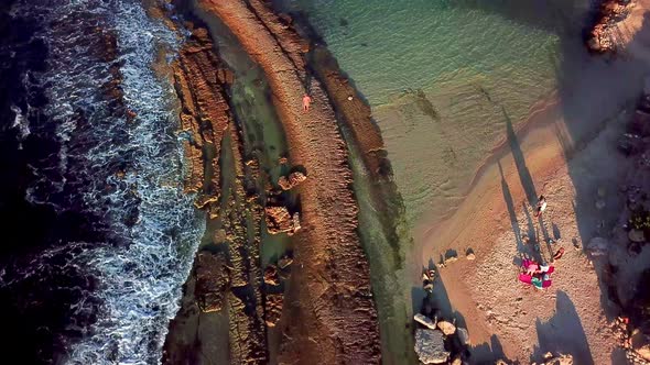 Tilt up aerial view of Kanoa Beach, family on the shore enjoying the sunset, Curacao, Dutch Caribbea