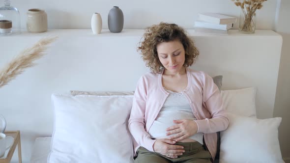Happy Young Pregnant Woman Touching Her Belly With Love And Care Waiting For Her Baby.