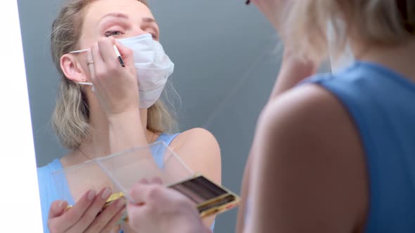 Blonde Girl in Medical Protective Mask Does Eye Makeup Applies Eye Shadow