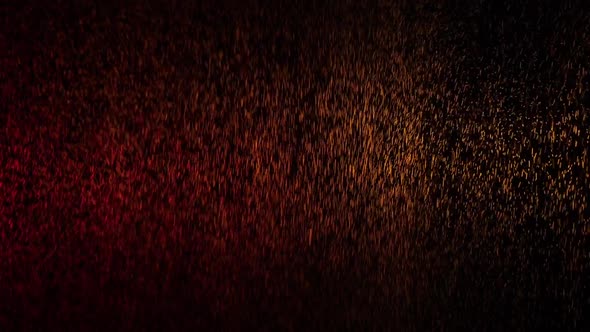 Red and Yellow Water Spray Mixed on a Black Background. Slow Motion alt
