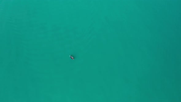 Drone flight over fishing boats in turquoise green sea