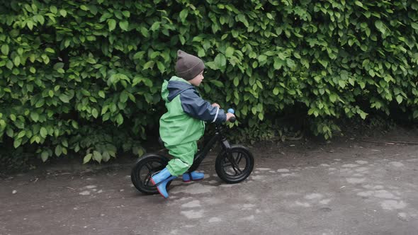 Funny Kid in Rain Boots Playing in a Rain Park