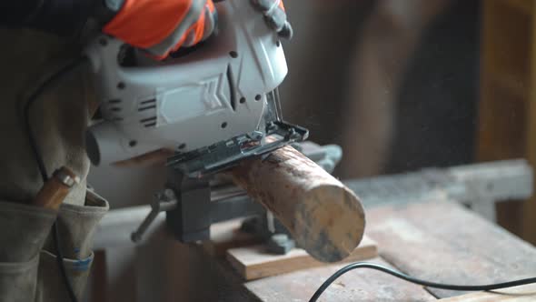 Crop carpenter cutting wood with fretsaw