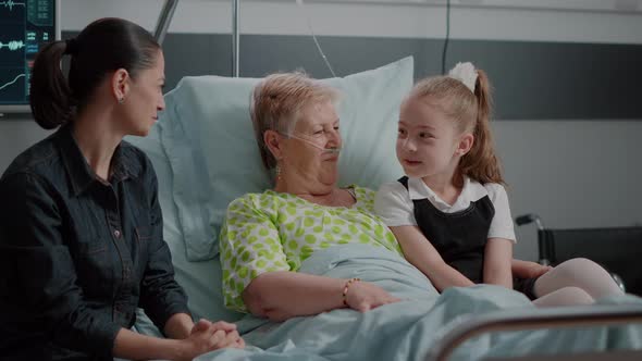 Niece and Sick Grandma Hugging at Family Visit in Hospital Ward