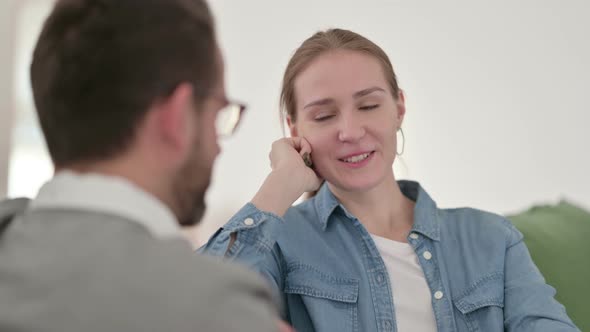 Woman Having Conversation with Man on Sofa