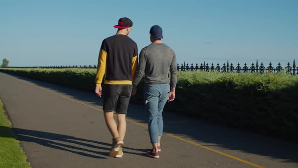 Rear View of Gay Couple in Love Strolling Outdoors