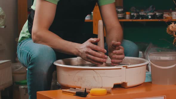 A Man Wet His Hands and Continue Sculpting the Figure on Pottery Wheel