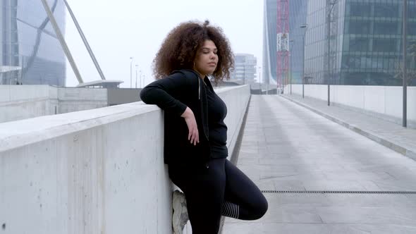 Plus size sportive young woman posing in the city