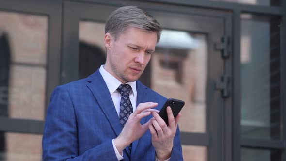 Portrait of Businessman Busy Using Smartphone