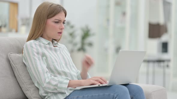 Sick Young Woman with Laptop Coughing at Home 