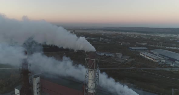 Aerial top view of steel factory. Smoking chimneys of industrial buildings