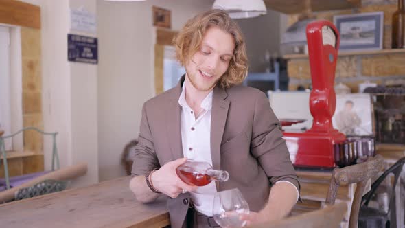 Male sommelier pouring fruit wine at a bar