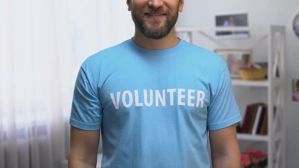 Confident Man in T-Shirt With Volunteer Inscription Smiling to Camera, Support