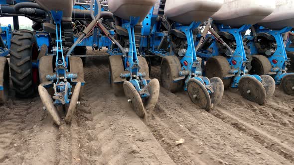 Closeup of Tractor with Seeder in the Field. Sowing of Corn, Maize in Soil, with Pneumatic Sowing