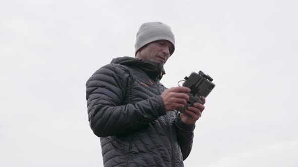 Photographer Using Remote Control Handset To Control Drone