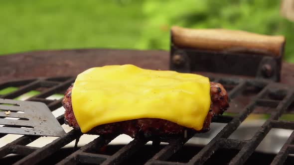 Closeup of the Homemade Burger Cutlet with Melted Cheese on the Top on a Grill