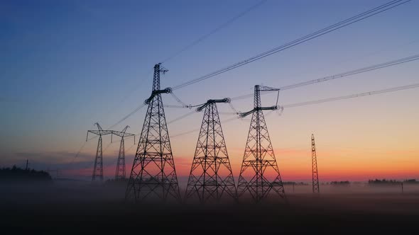 Aerial View High Voltage Steel Power Pylons in Field Covered with Fog Countryside