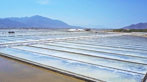 Salt Fields Flooded with Seawater Against Hills