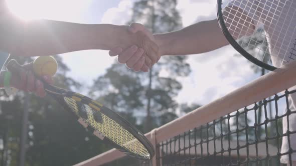 Mature Couple Shaking Hands After Playing Tennis on the Tennis Court